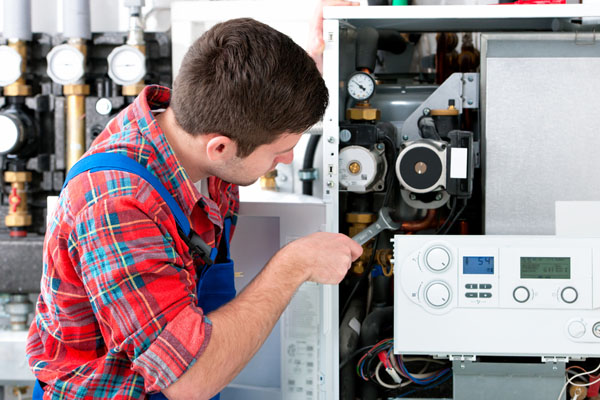Heating technician repairing boiler controls in Culver City