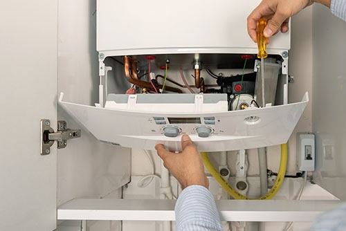 Heating technician repairing a residential boiler in Culver City