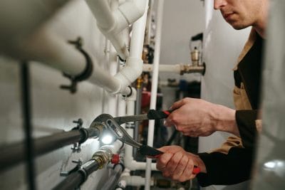 Technician inspecting commercial plumbing pipes in Culver City