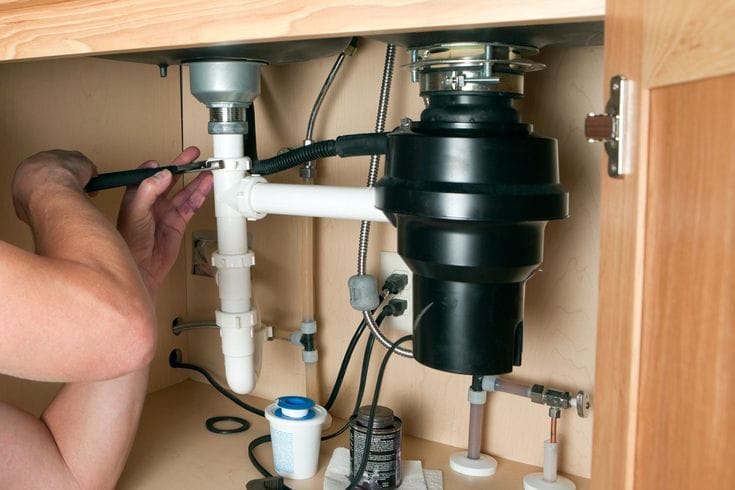 Plumber repairing a garbage disposal in Culver City
