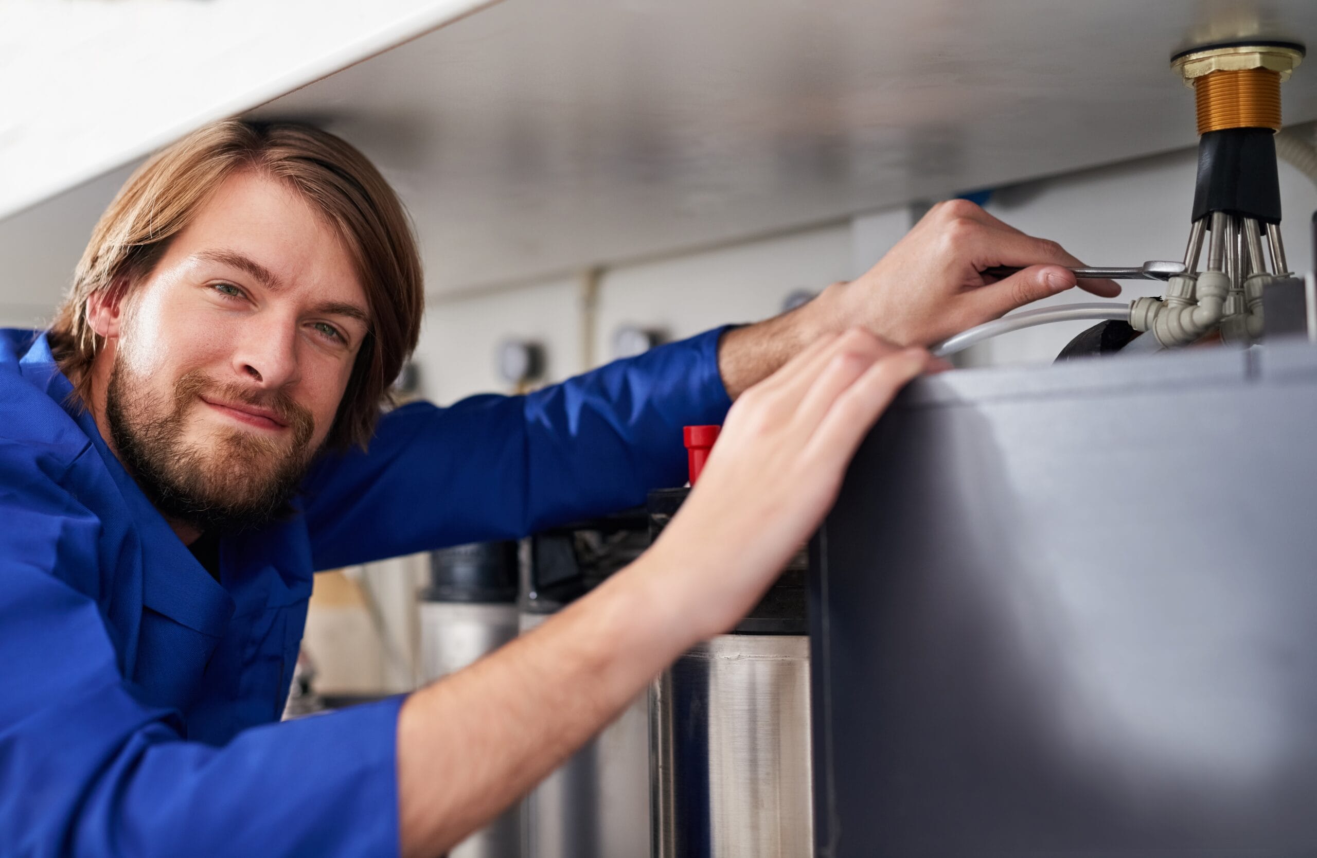 Technician servicing a residential water heater tank in Culver City